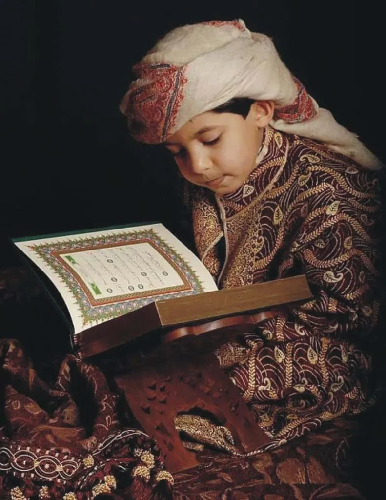 Young boy reading the Quran in traditional attire - Alzahra Quran Academy's online Quran classes for all ages